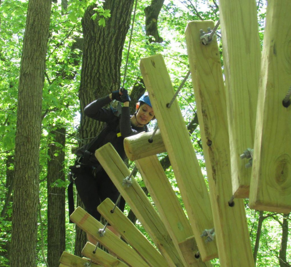 Helix Obstacle – NY Zipline Park person attempting to cross the helix obstacle at NY Zipline park