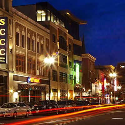 Night street scene with light trails, buildings, and illuminated signs including YMCA and SCCC.