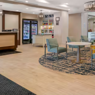 Hotel lobby with seating area, fireplace, and reception desk.