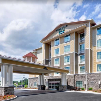 Exterior view of a modern hotel with a covered entrance and landscaped grounds.